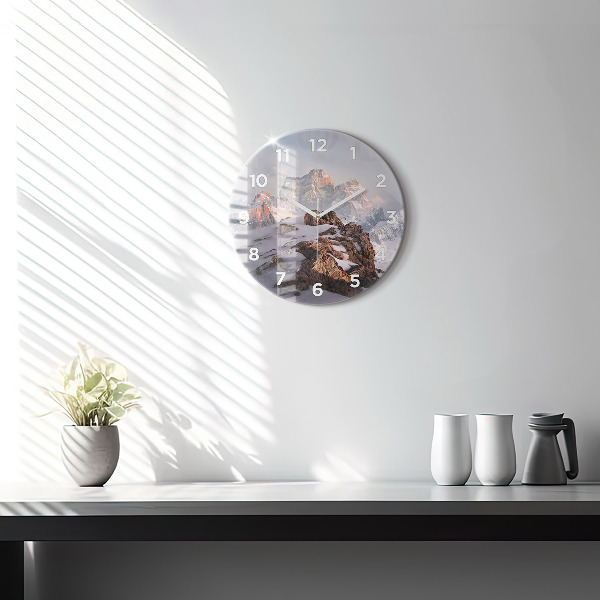 Round glass clock A mountain covered in snow