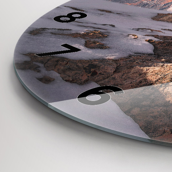 Round glass clock A mountain covered in snow