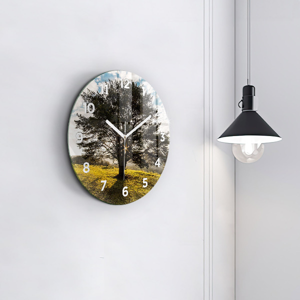 Round glass clock A tree on a hill