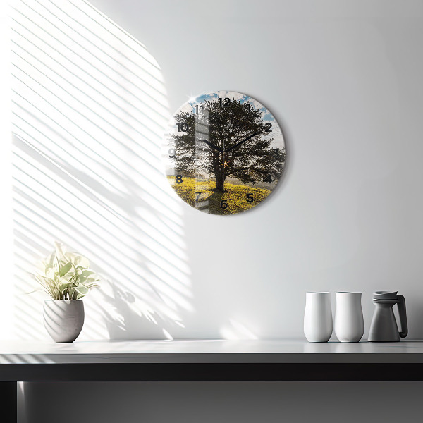 Round glass clock A tree on a hill