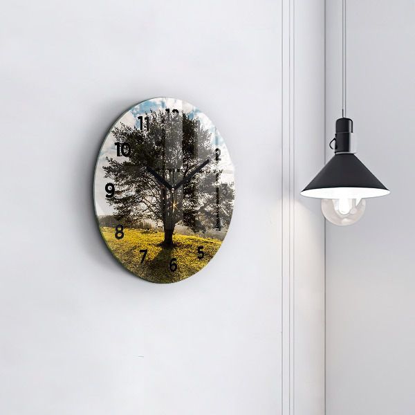 Round glass clock A tree on a hill