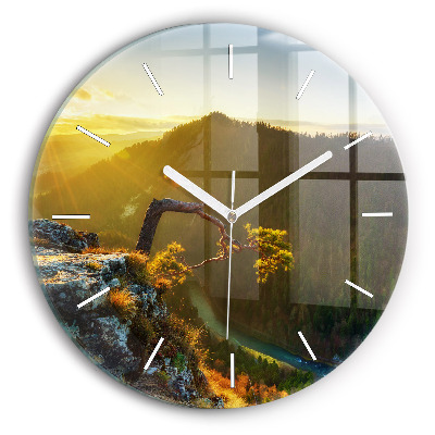 Round glass clock Sunset over the mountains